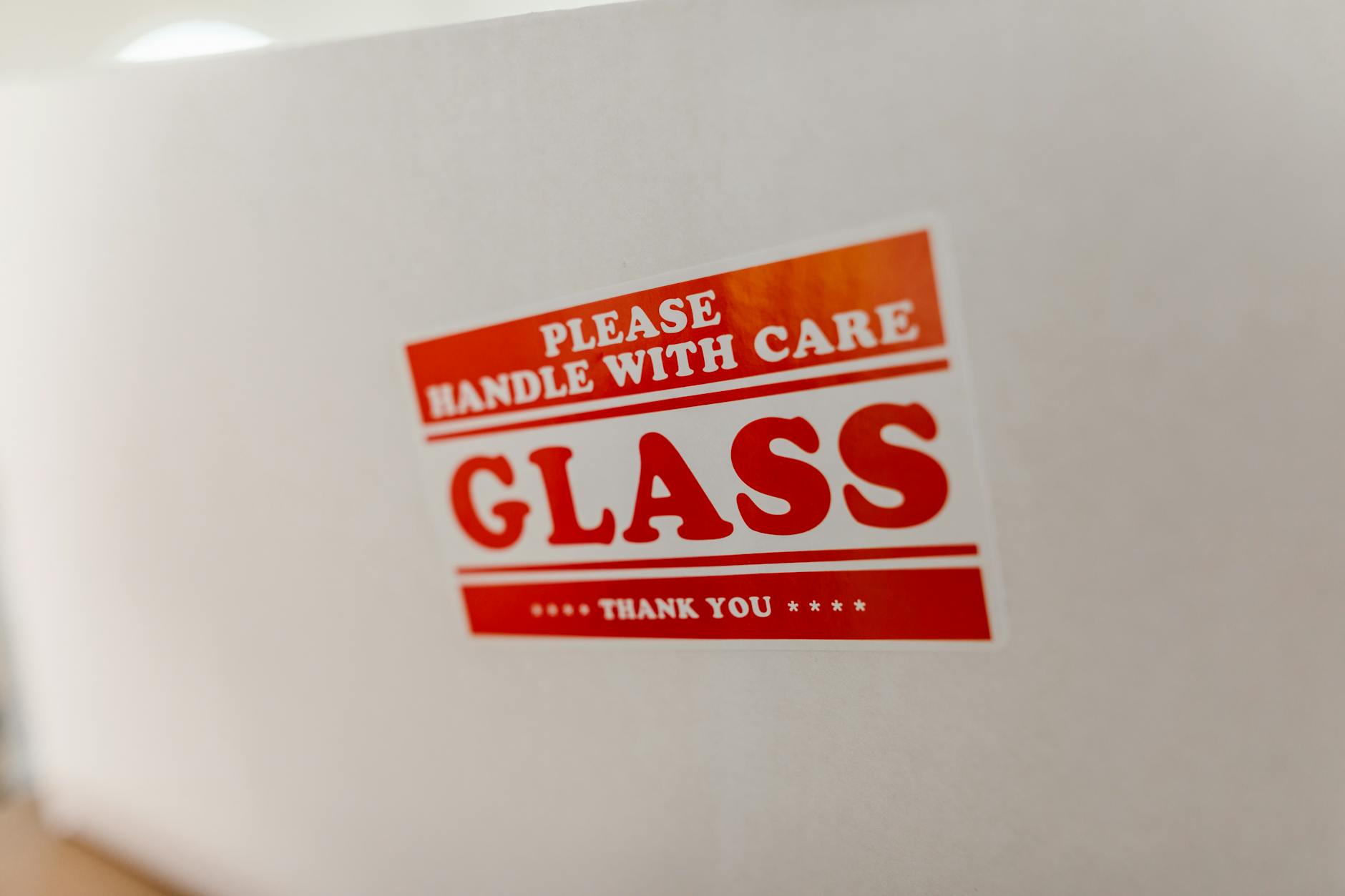 Zbliżenie na etykietę szklanego opakowania z napisem handle with care