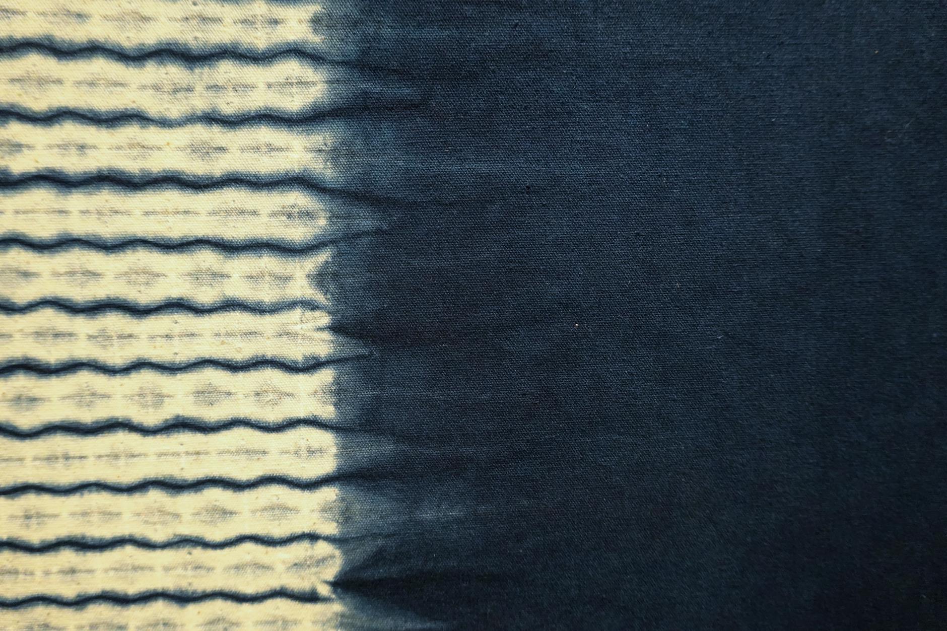 Granatowa tkanina barwiona indygo z falistym wzorem od jasnego do ciemnego