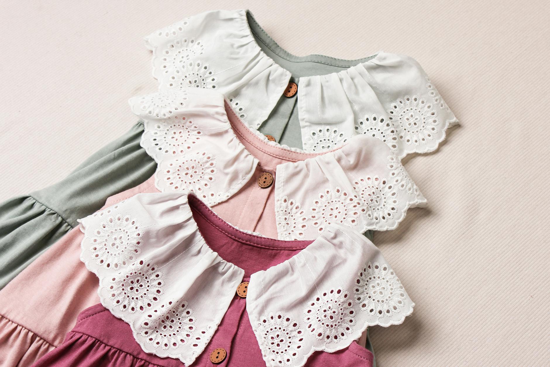 Pastelowe sukienki niemowlęce z koronkowymi kołnierzykami