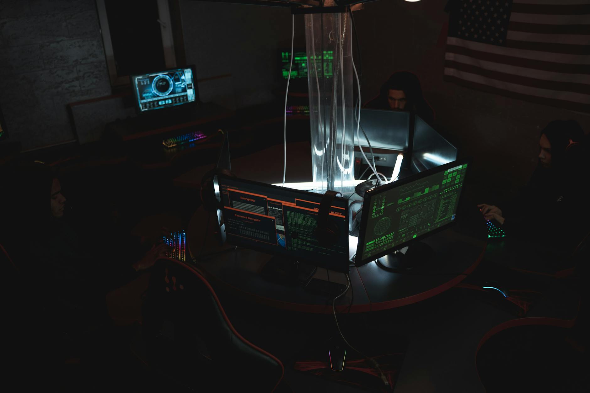 Specjaliści ds. cyberbezpieczeństwa analizują dane na monitorach w ciemnym biurz