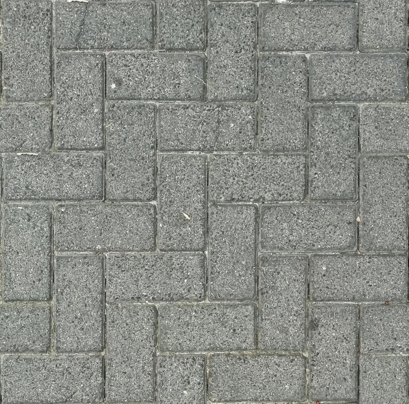 Szara kostka brukowa ułożona w jodełkę, widok z góry