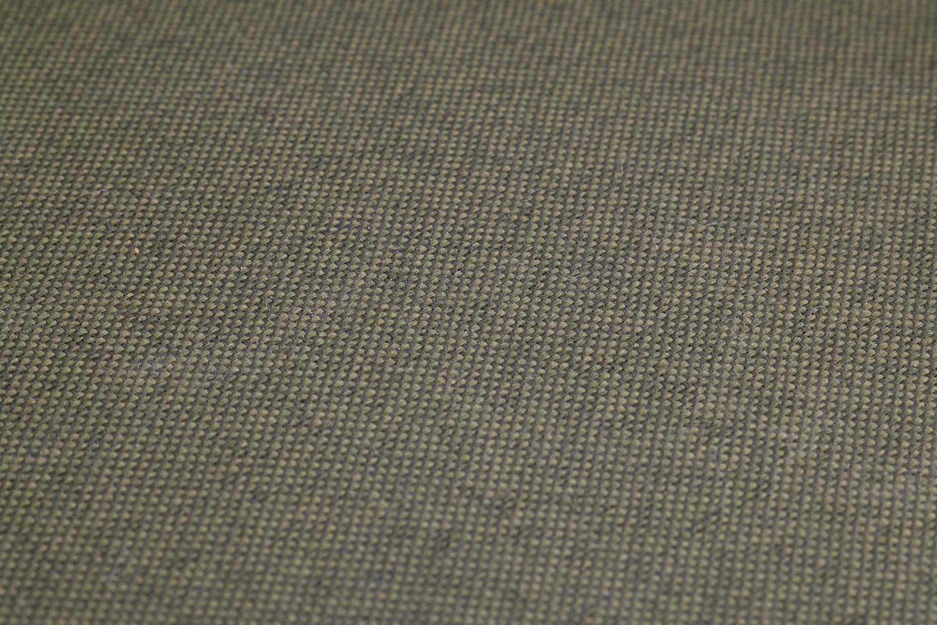 Zbliżenie oliwkowej tkaniny obiciowej o wyraźnym, gęstym splocie