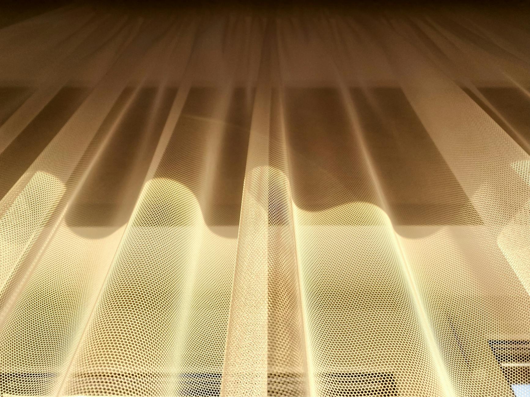 Złote, półprzezroczyste zasłony kuchenne oświetlone słońcem