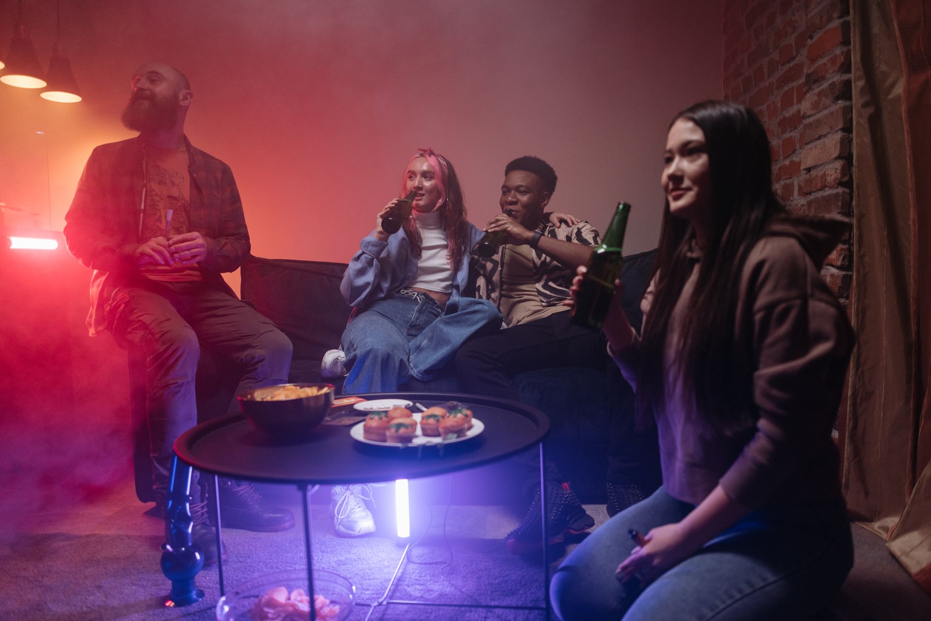 Grupa przyjaciół bawi się przy przekąskach i drinkach na domówce